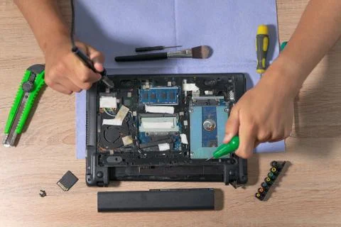 Engineer fixing broken computer at work. Electronic repair shop. Computer mai Stock Photos
