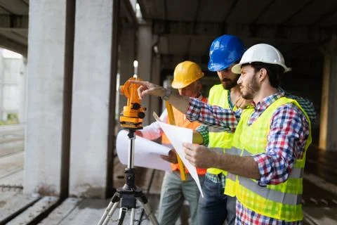 Engineer, foreman and worker discussing in building construction site 스톡 사진