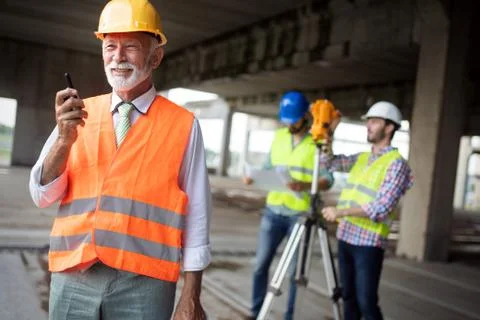 Engineer, foreman and worker discussing in building construction site Fotos de archivo