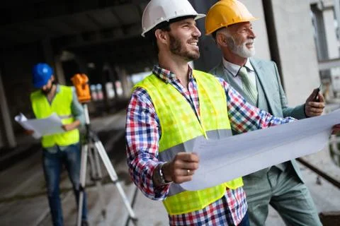 Engineer, foreman and worker discussing in building construction site Fotos de archivo