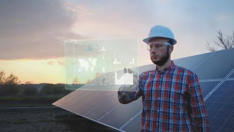 Engineer in front of solar panel works on futuristic table HUD display Stock Photos