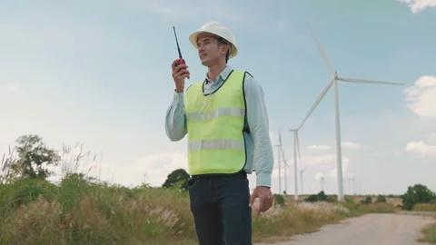 Engineer is giving orders with a walkie-talkie while inspecting work Stock Footage 274381781