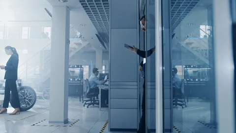 Engineer with Glasses and Beard Enters a High Tech Development Facility Stock Footage