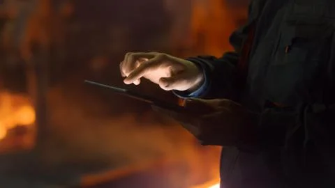 Engineer in Glasses using Tablet PC in Foundry. Industrial Environment. Stock Photos