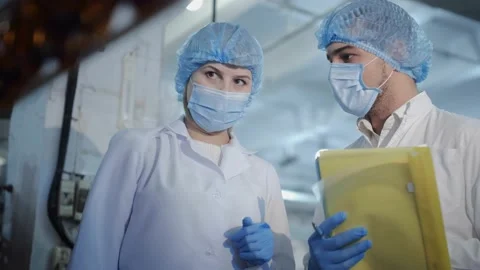 Engineer in gloves and mask shows equipment to guy trainee 스톡 동영상 145550044