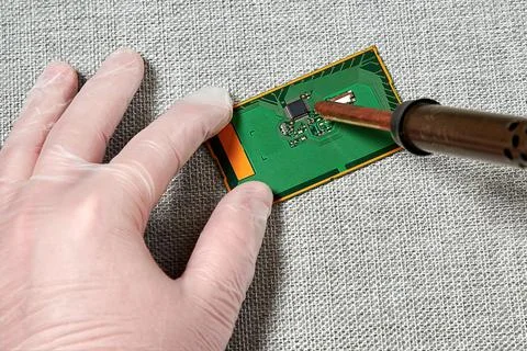 An engineer in gloves developing a PCB with a microchip Foto stock