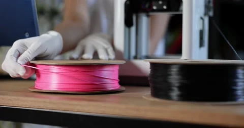 Engineer in gloves works with pink plastic for 3D printers Stock Footage 233022667