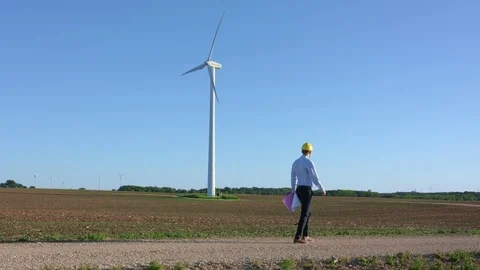 Engineer goes against the background of windmills Stock-Footage 76552439