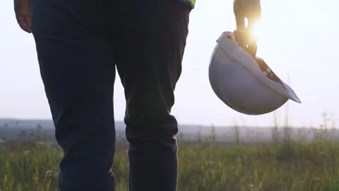 The engineer goes to meet the sunset. Helmet in hand Stock Footage 254506121