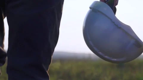 The engineer goes to meet the sunset. Helmet in hand Stock Footage 254604885