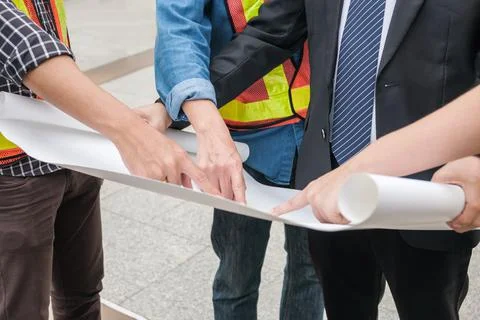 Engineer group pointing to paper sheet with businessman Stock Photos