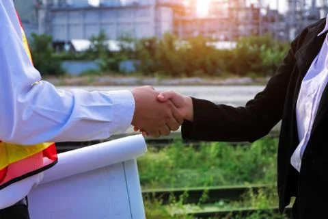 The engineer guy is shaking hands with construction manager. Stock Photos