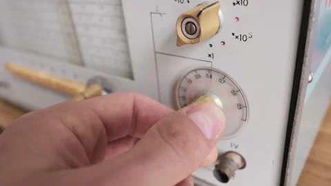 Engineer Hand Adjusting Dial on Vintage Analog Frequency Signal Generator Stock Footage 333820427