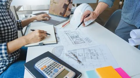 Engineer Hand Drawing Plan On Blue Print with architect equipment discussing Stock Photos