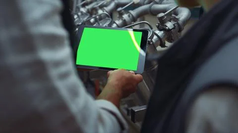 Engineer hands swiping tablet with chroma key screen at steal equipment closeup Stock Photos
