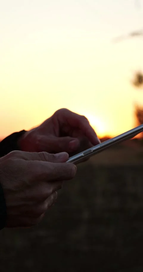 Engineer hands use tablet at sunset for smart grid control. Close-up shows Stock Footage 348430708