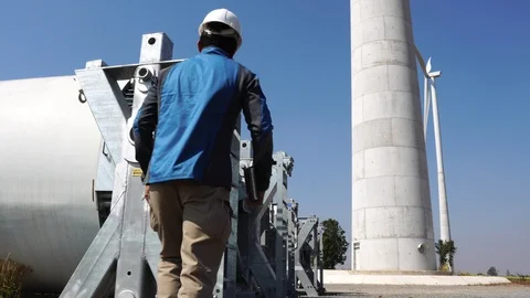 Engineer with hard hat against wind turbine  動画素材 121198375