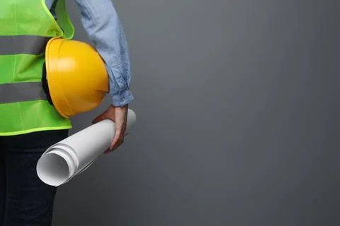 Engineer with hard hat and draft on grey background, closeup. Space for text Stock Photos