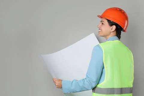 Engineer in hard hat with draft on grey background, space for text Stock Photos