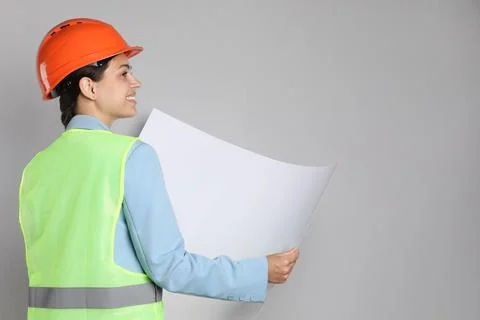 Engineer in hard hat with draft on grey background, space for text Stock Photos