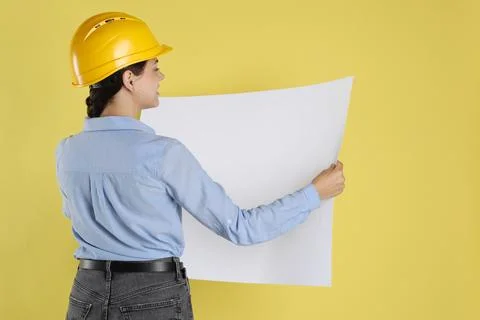 Engineer in hard hat with draft on yellow background, space for text Stock Photos