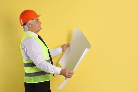 Engineer in hard hat with draft on yellow background, space for text Stock Photos