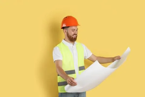 Engineer in hard hat with draft on yellow background, space for text Stock Photos