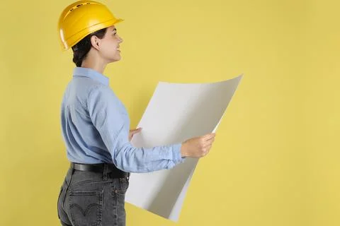 Engineer in hard hat with draft on yellow background, space for text Stock Photos