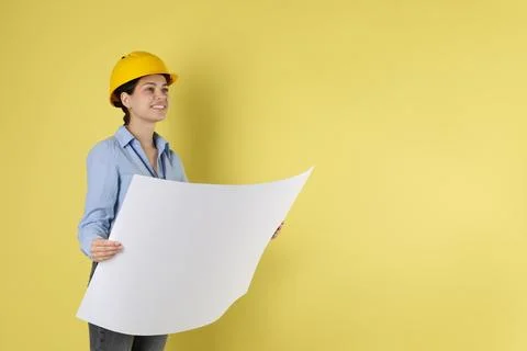 Engineer in hard hat with draft on yellow background, space for text Stock Photos