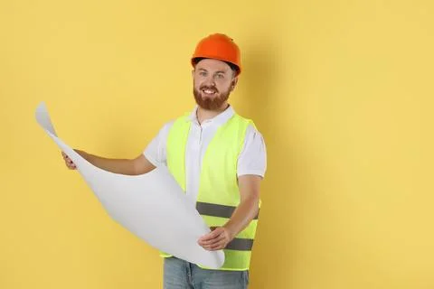 Engineer in hard hat with draft on yellow background, space for text Stock Photos