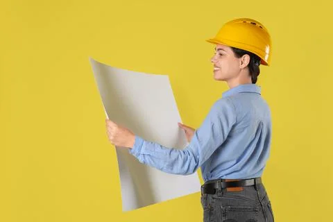 Engineer in hard hat with draft on yellow background, space for text Stock Photos