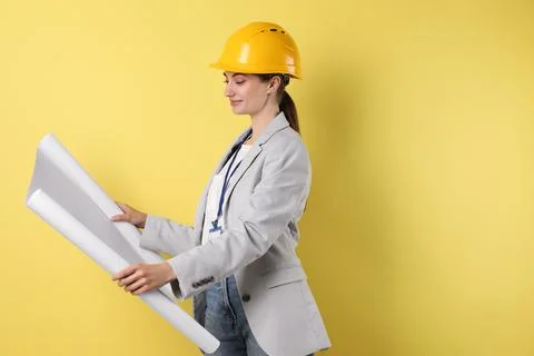 Engineer in hard hat with draft on yellow background, space for text Stock Photos