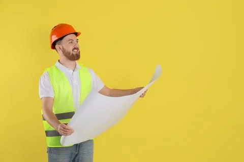 Engineer in hard hat with draft on yellow background, space for text Stock Photos