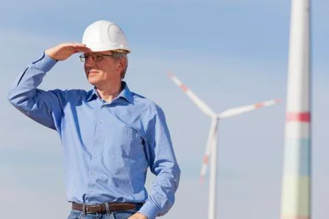 Engineer with hard hat in front of a windfarm Stock Photos