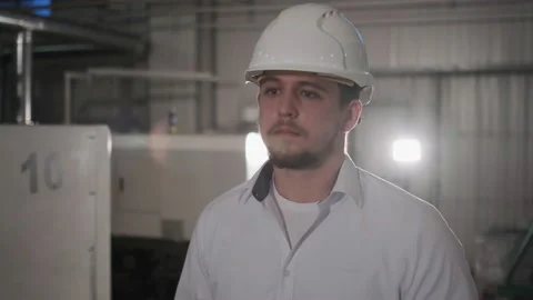 Engineer in hard hat is moving through a heavy industry factory with a tablet Stock Footage 114503253