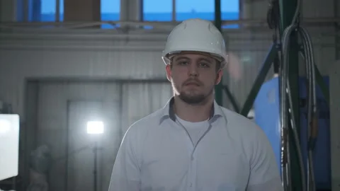 Engineer in hard hat is moving through a heavy industry factory with a tablet Stock Footage 114503321