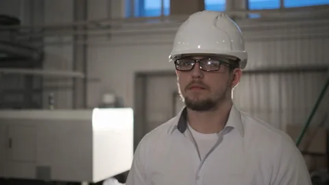 Engineer in hard hat is moving through a heavy industry factory with a tablet Stock Footage 114503396