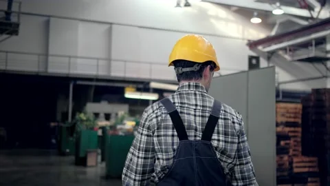 Engineer in hard hat is moving through a heavy industry factory with a tablet Stock Footage 171775861
