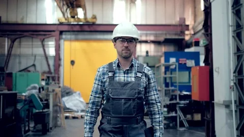 Engineer in hard hat is moving through a heavy industry factory with a tablet Stock Footage 171775936