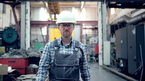 Engineer in hard hat is moving through a heavy industry factory with a tablet Stock Footage 171775983