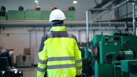 Engineer in hard hat is moving through a heavy industry factory with a tablet Stock Footage 171776173