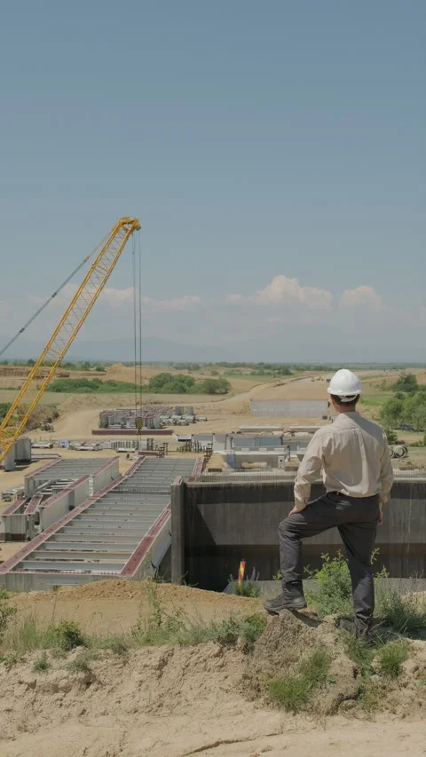 Engineer in hard hat overseeing highway viaduct construction with concrete .. Stock Footage 338008693