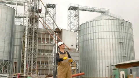 An engineer in a hard hat with a project in hand checks the construction status  Stock Footage 271629591