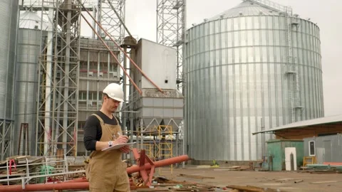 An engineer in a hard hat with a project in hand checks the construction status  Stock Footage 271629668