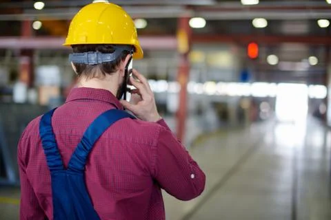 Engineer in hard hat talking on the phone shot from the back. Stock Photos