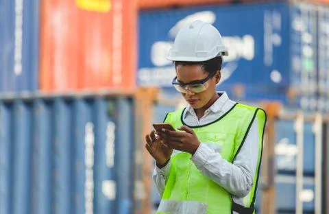 Engineer in the hard hat uses mobile phone, worker using mobile smartphone 写真素材