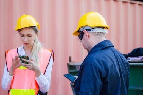 Engineer in the hard hat uses mobile phone, Industrial worker using mobile sm 库存照片