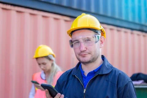 Engineer in the hard hat uses mobile phone, Industrial worker using smartphone Fotos de archivo