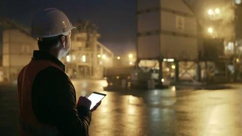 Engineer in hardhat checking the loading of truck with a tablet computer on Stock Footage 69827716