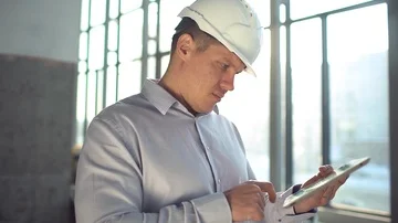 Engineer in hardhat is holding a tablet computer in a heavy industry factory Stock Footage 85901237